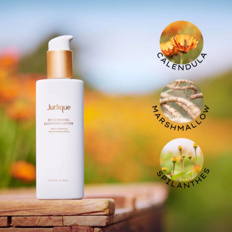 Jurlique replenishing cleansing lotion bottle with natural ingredients icons on a blurred outdoor background
