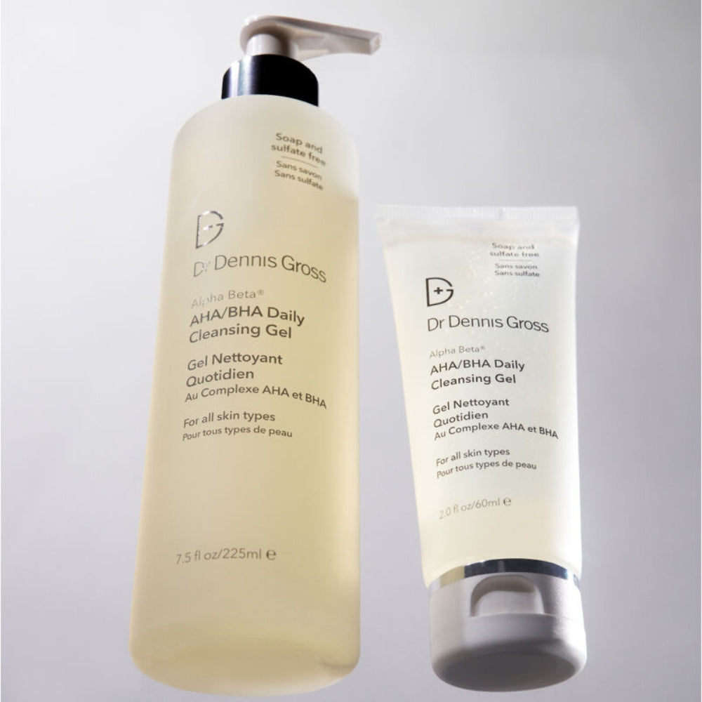 Two Dr. Dennis Gross skincare bottles on a light gray background: a large pump bottle of AHA/BHA Daily Cleansing Gel and a smaller squeeze tube of the same product.