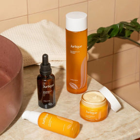 Jurlique skincare products on a bathroom counter with a tiled wall background